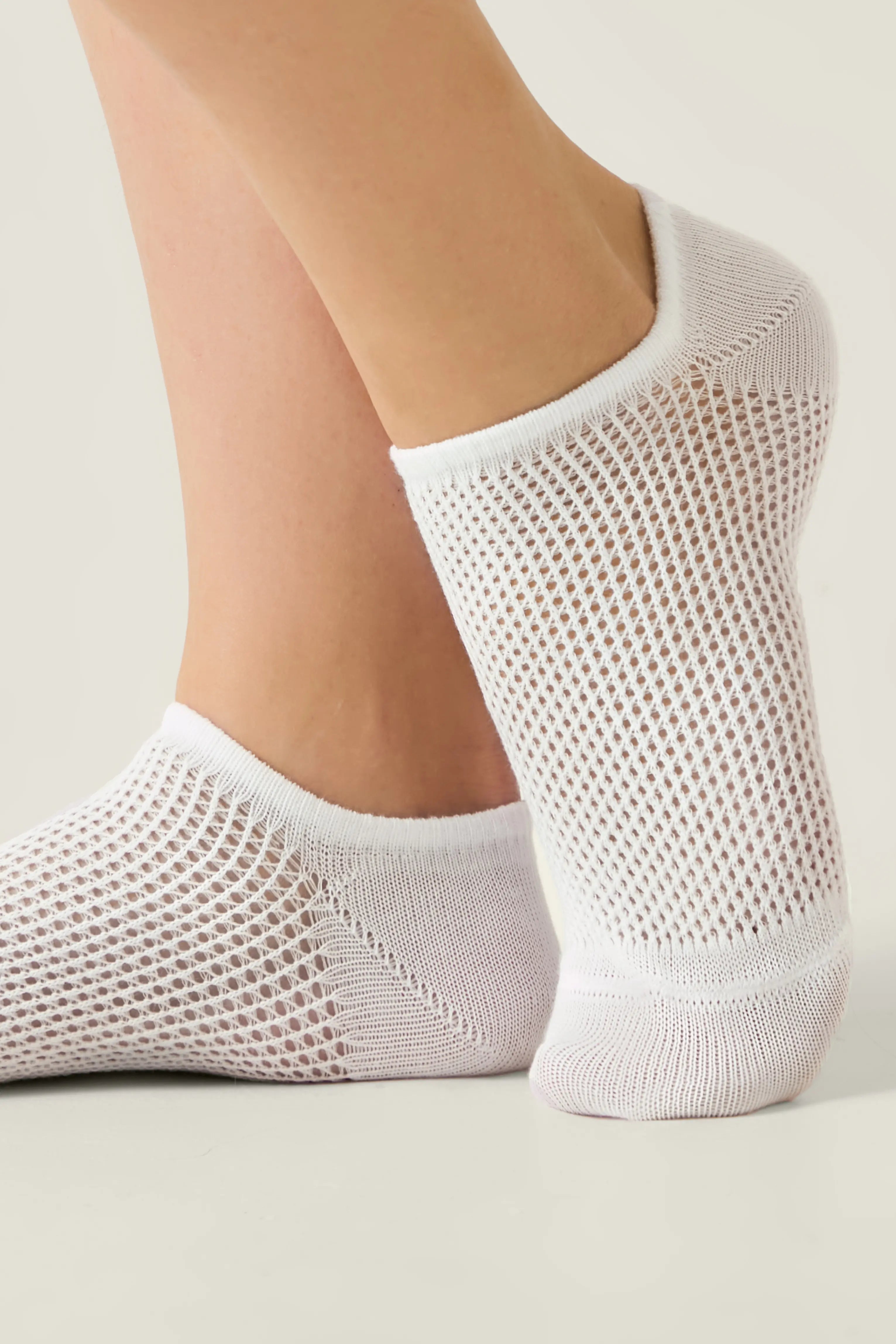 White mesh ankle socks worn by a person on a light background #color_white