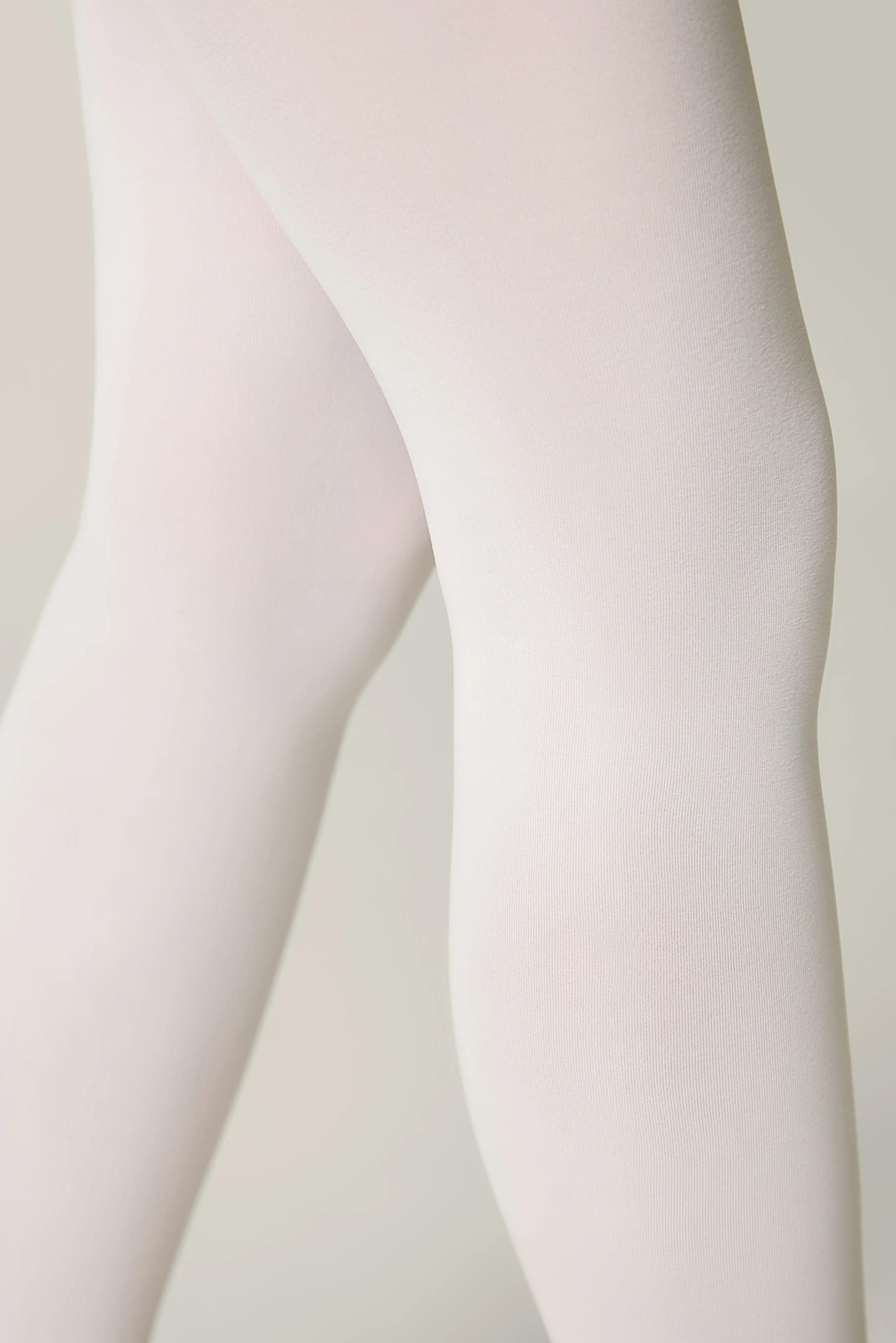 Close-up of a person wearing light pink tights against a neutral background #color_bianco