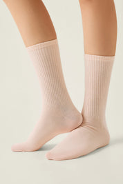 Light pink socks worn by a person on a neutral background #color_peach