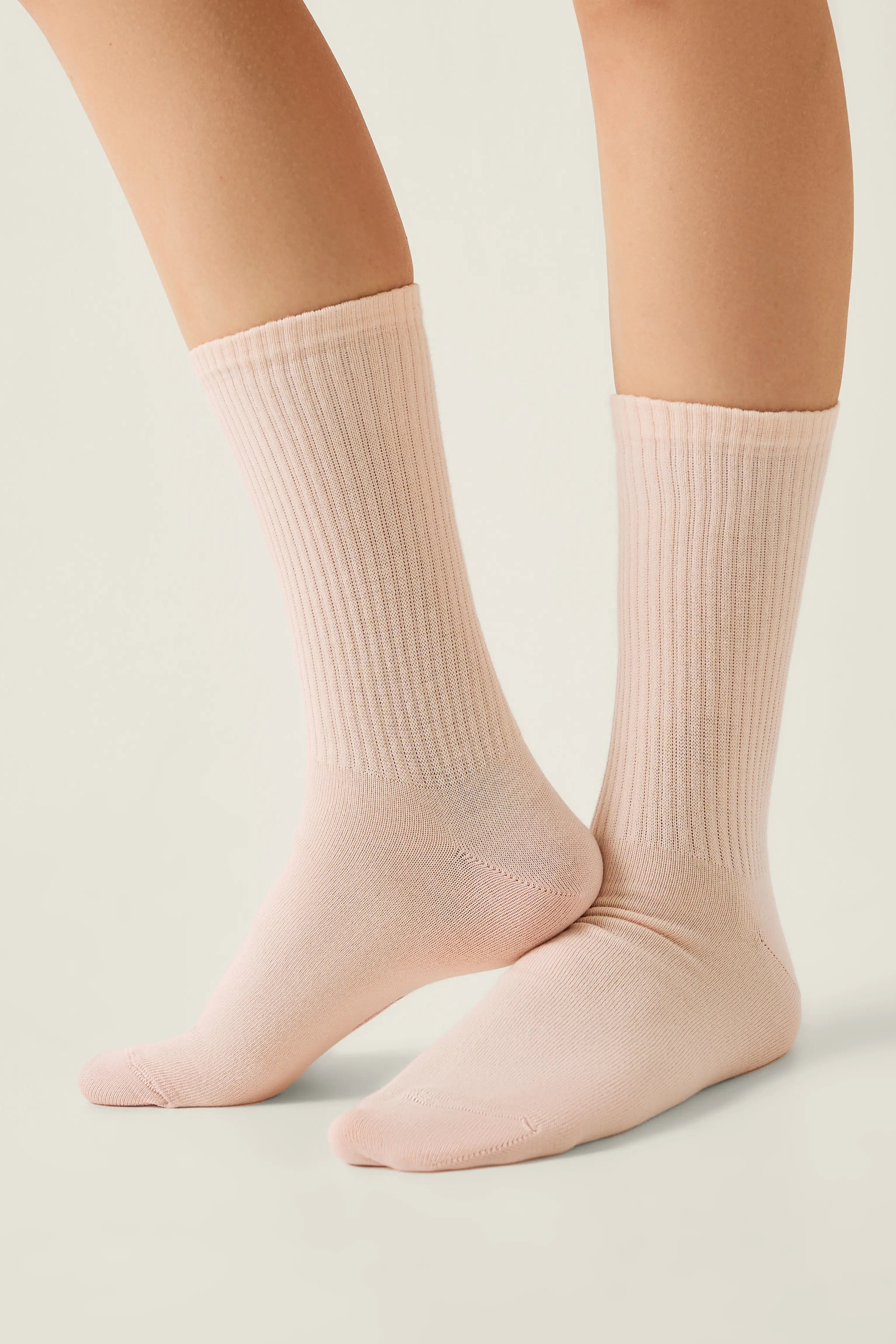 Light pink socks worn by a person on a neutral background #color_peach