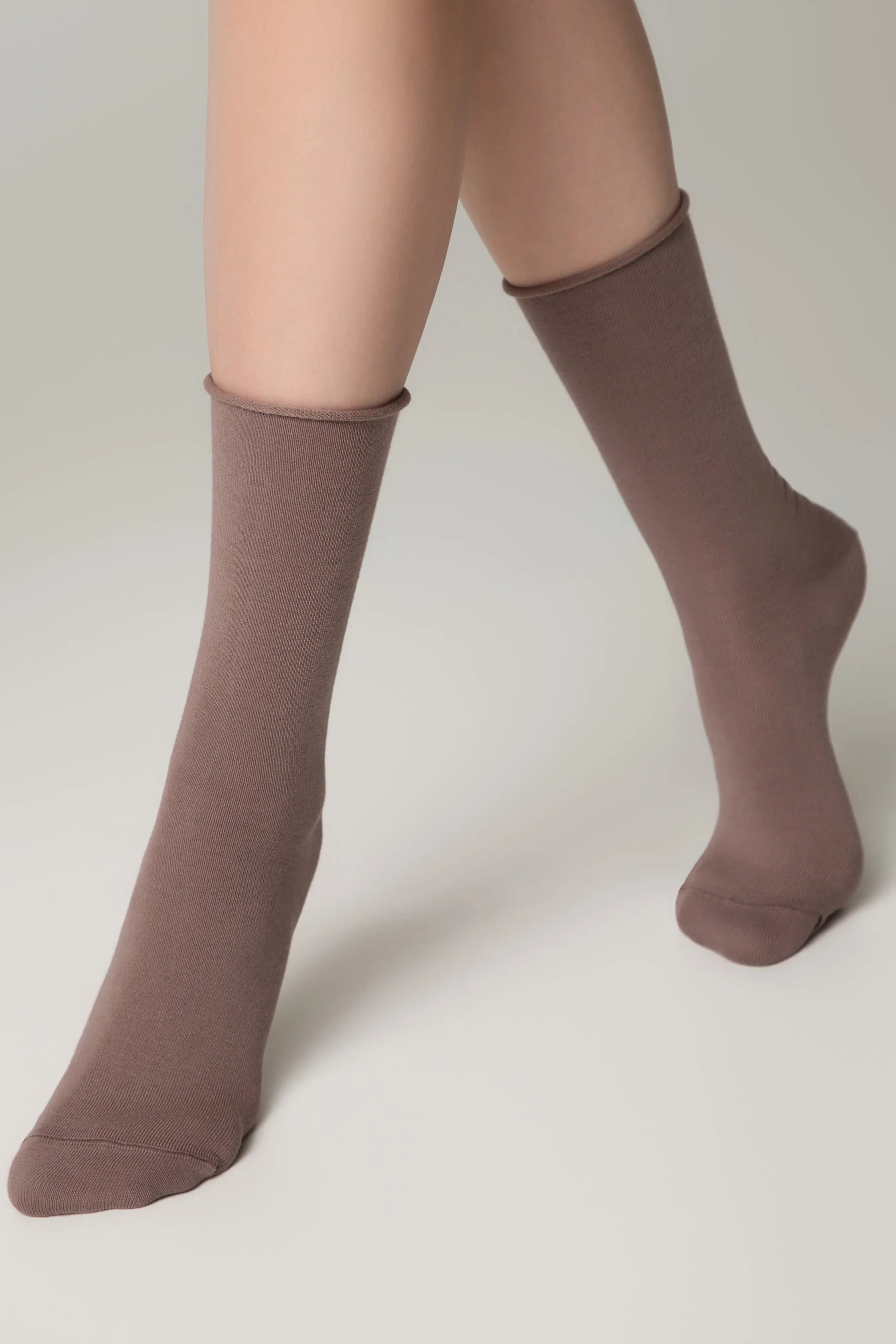 Brown socks worn by a person on a plain background #color_cocoa