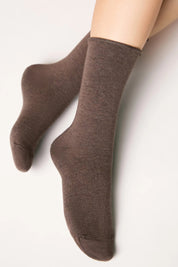 Brown socks worn by a person on a light gray background #color_brown
