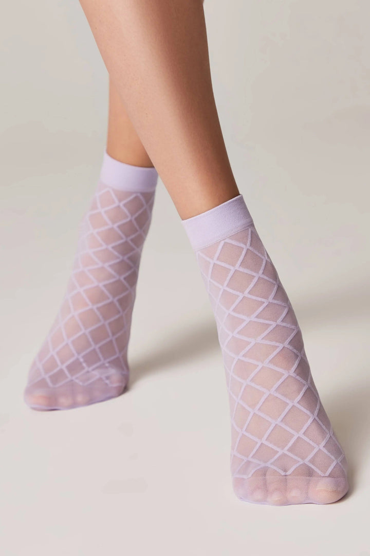 Sheer fishnet socks with grid pattern worn by a person on a plain background #color_violet
