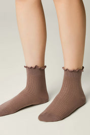 Brown socks with ruffled top worn by a person on a neutral background #color_coffee