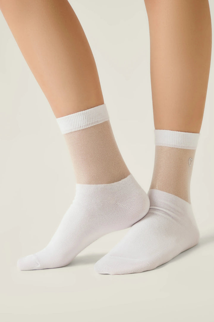 White ankle socks worn by a person on a plain background #color_white