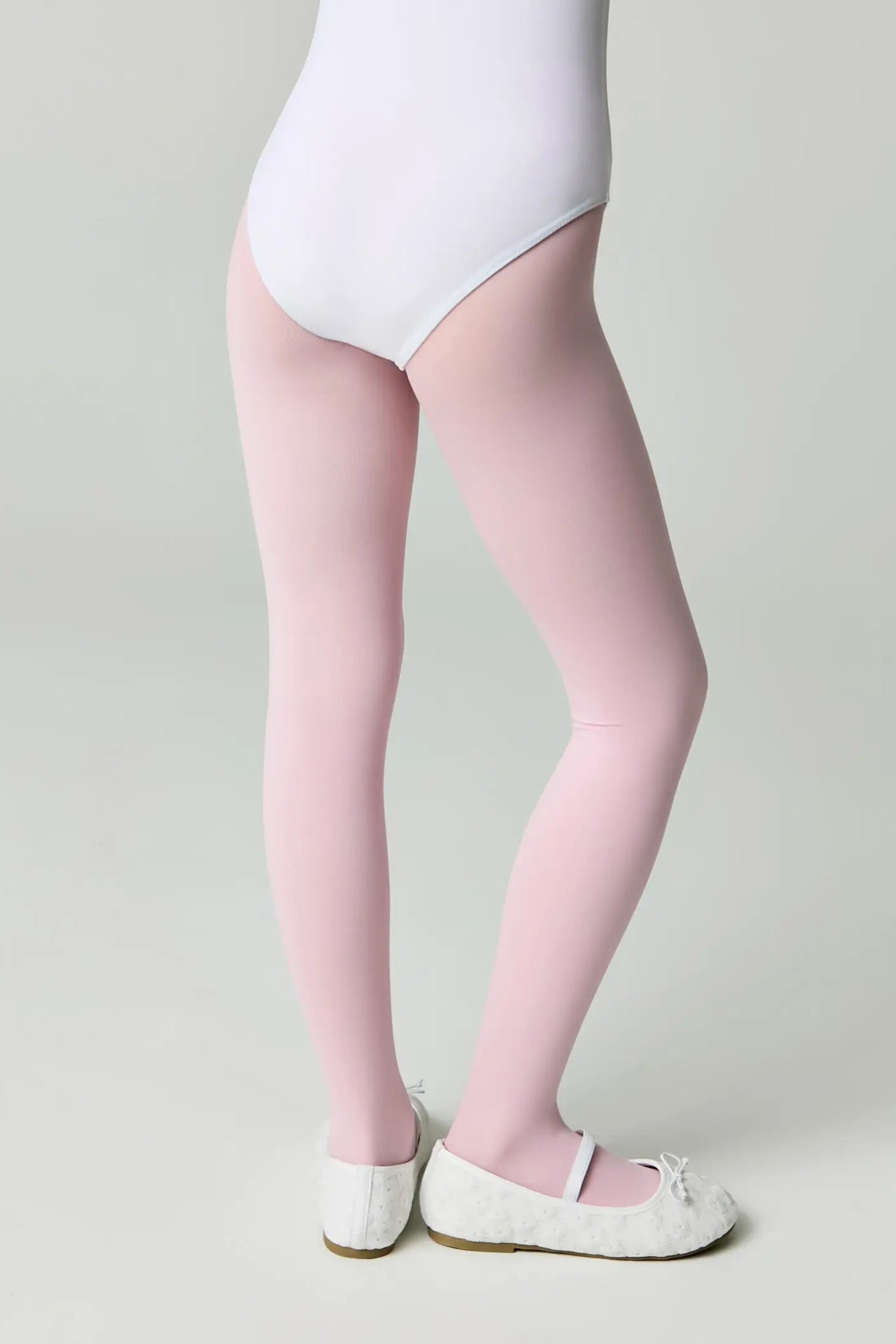 Person wearing pink tights and white shoes on a plain background #color_pink