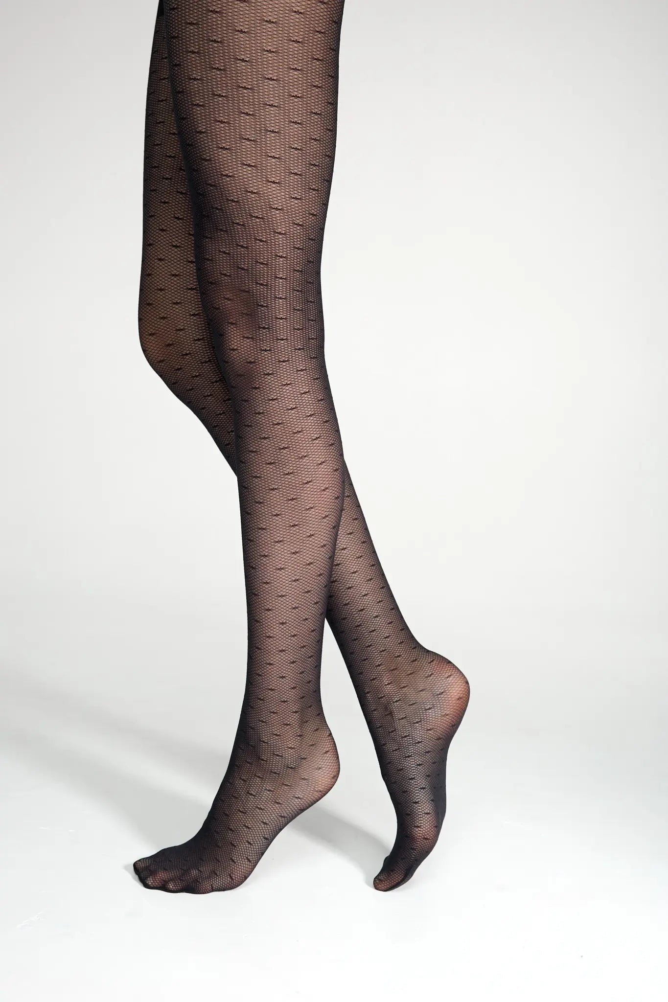 Black patterned tights worn by a person on a white background #color_grafit