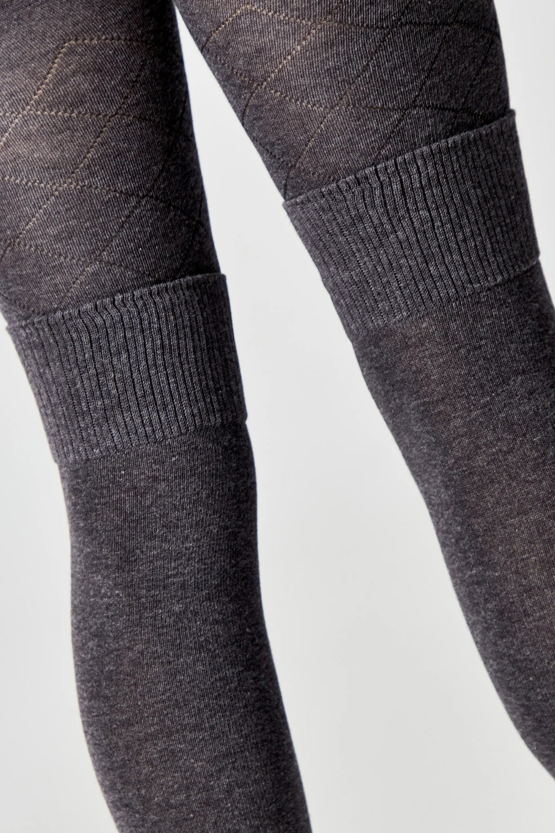 Close-up of dark gray tights with textured pattern on a light gray background #color_dark-gray