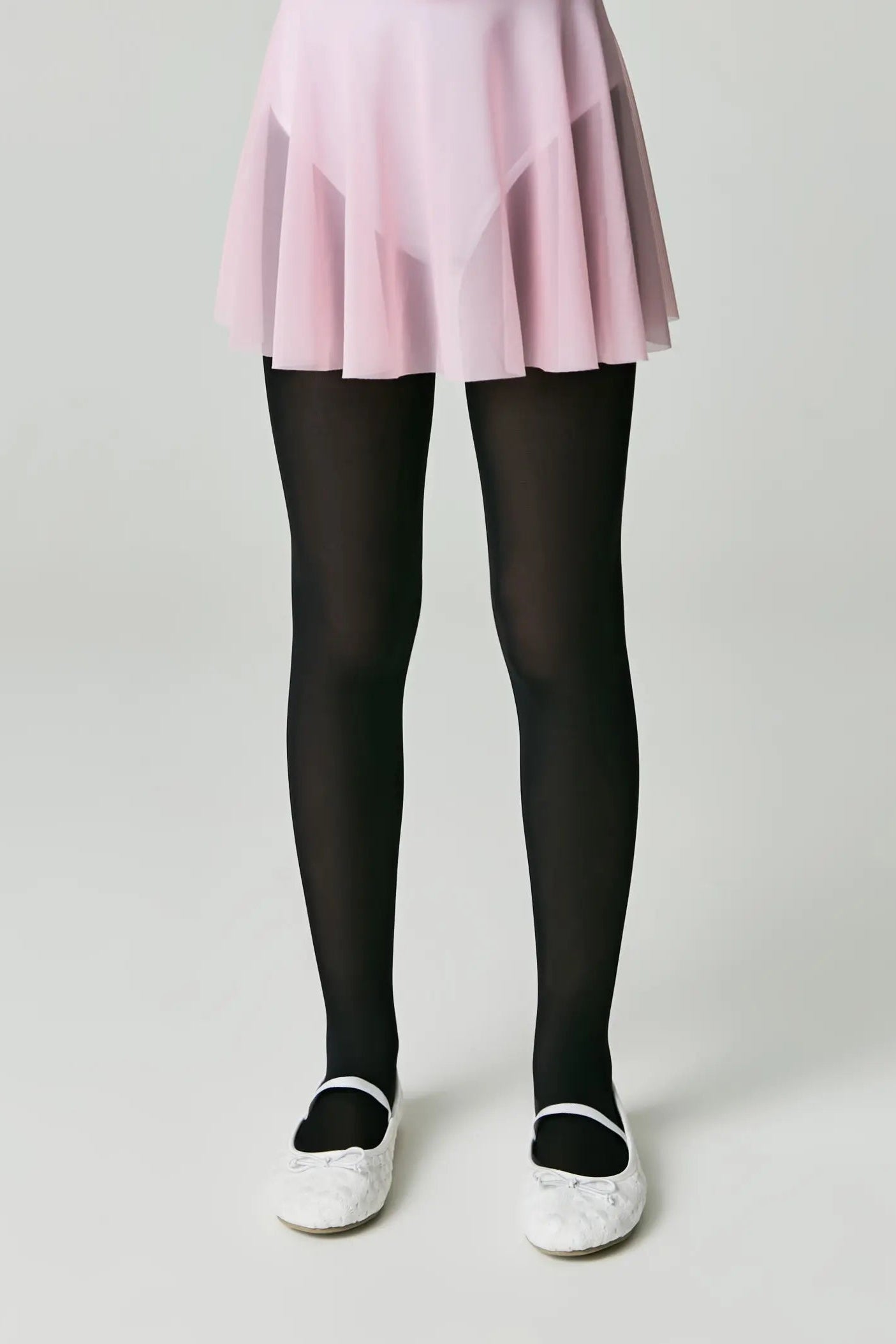 Person wearing a pink skirt and black tights on a plain background #color_nero-black