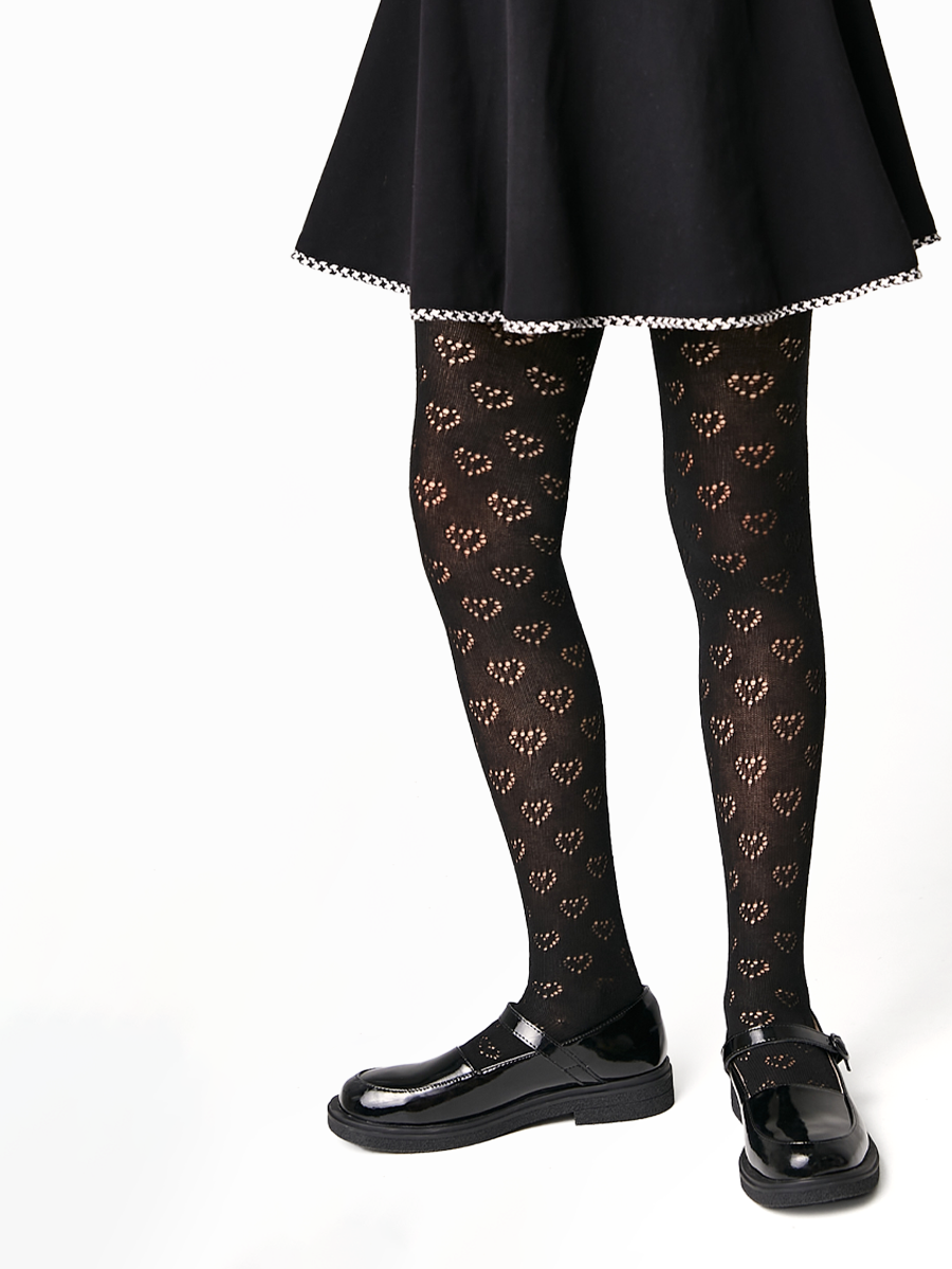 Black tights with heart pattern worn by a person on a white background #color_black