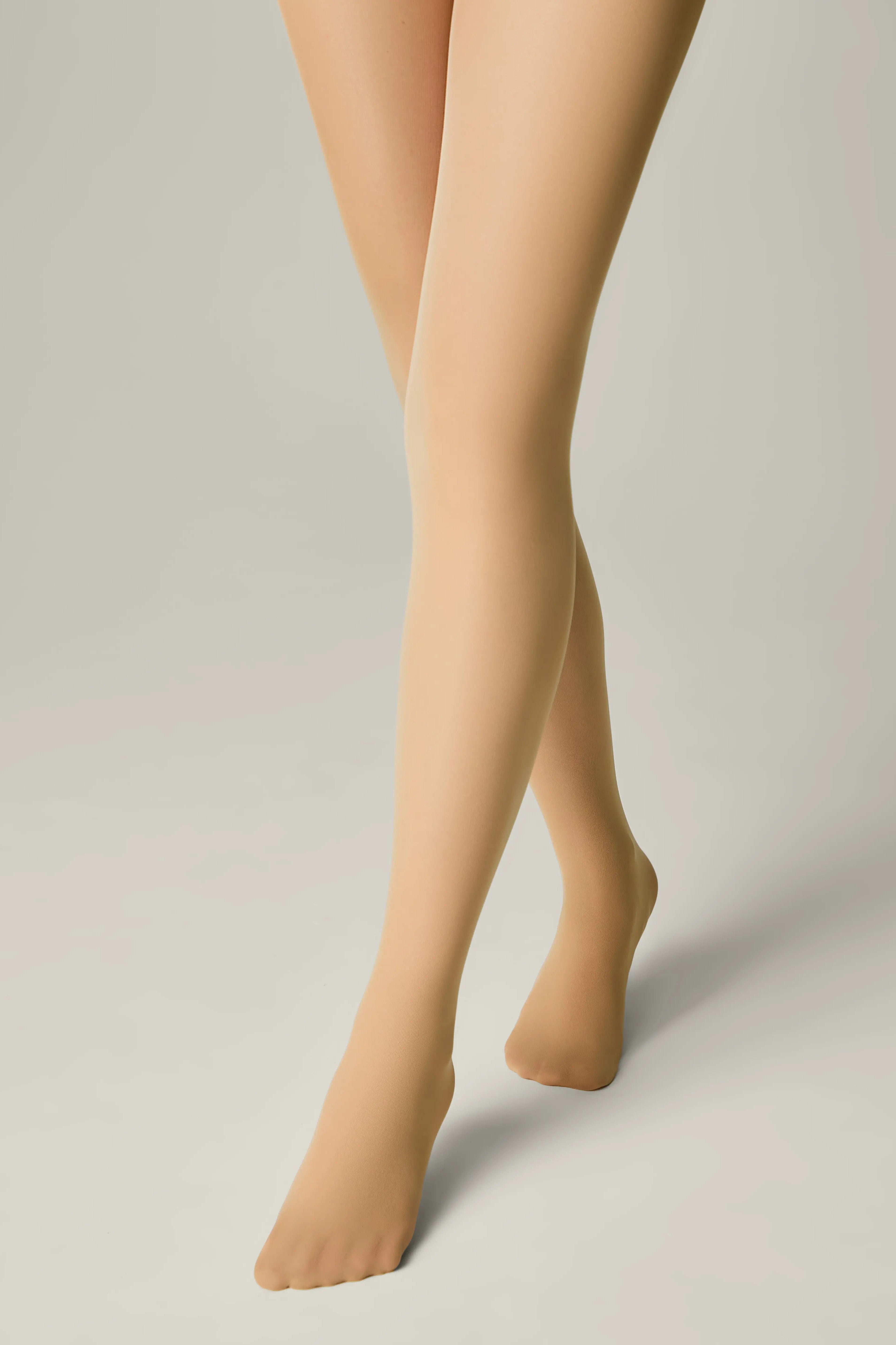 Beige tights worn by a person on a plain background #color_natural-nude
