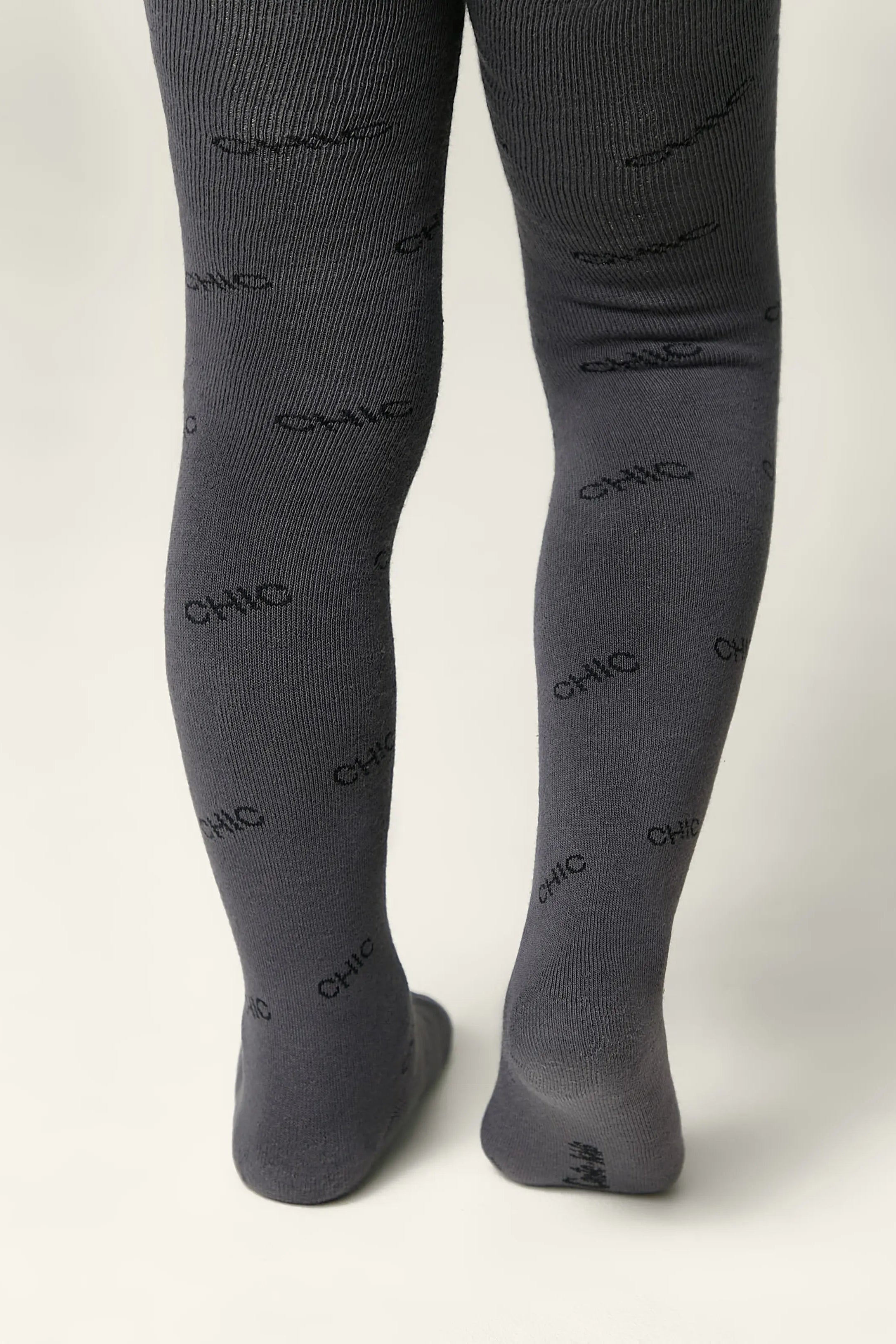 Gray tights with 'CHIC' print worn by a person on a white background #color_dark-gray
