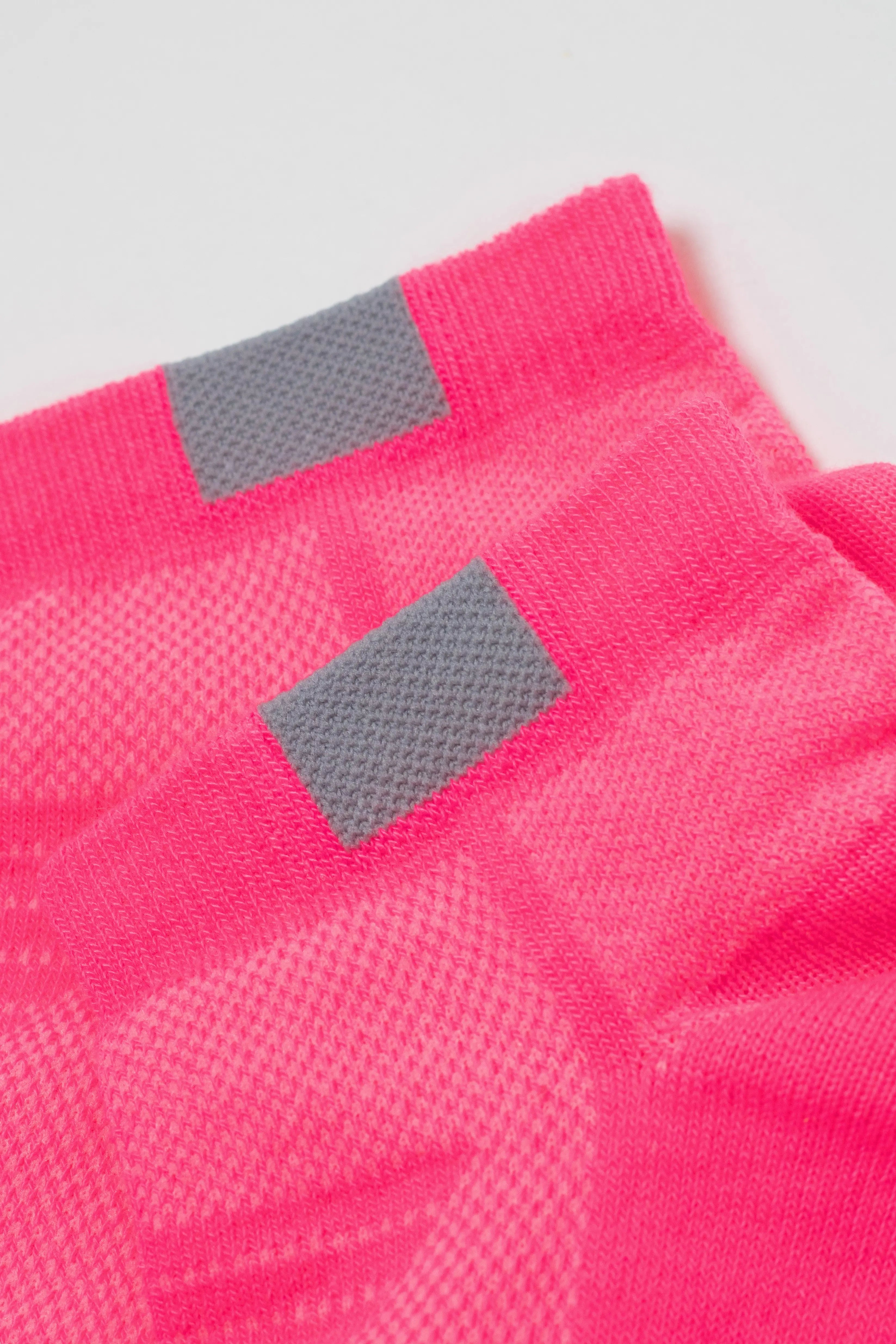 Close-up of pink socks with gray accents on a light gray background #color_pink
