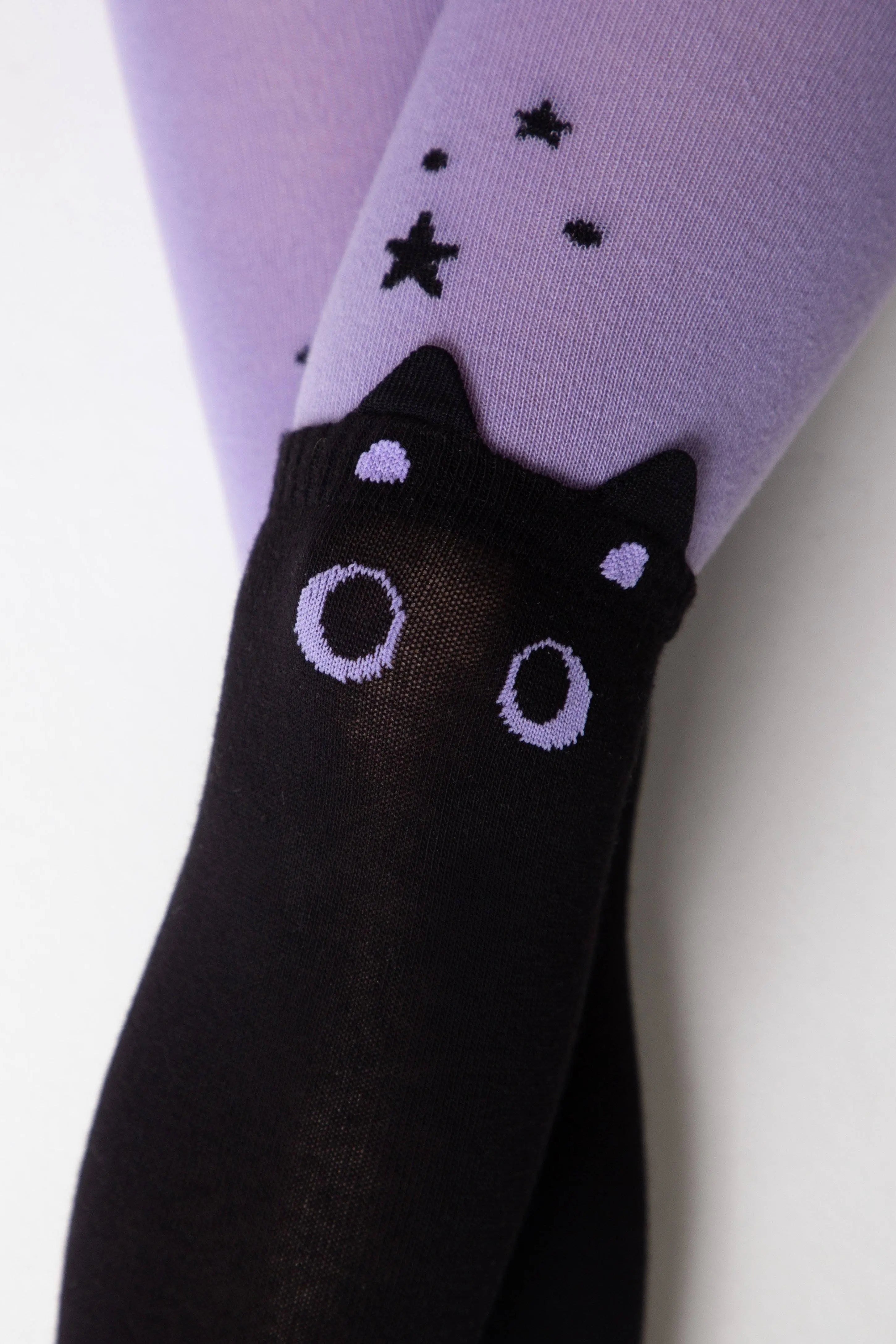 Black cat-themed tights with purple accents on a white background