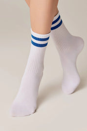 White socks with blue stripes worn by a person on a beige background #color_blue