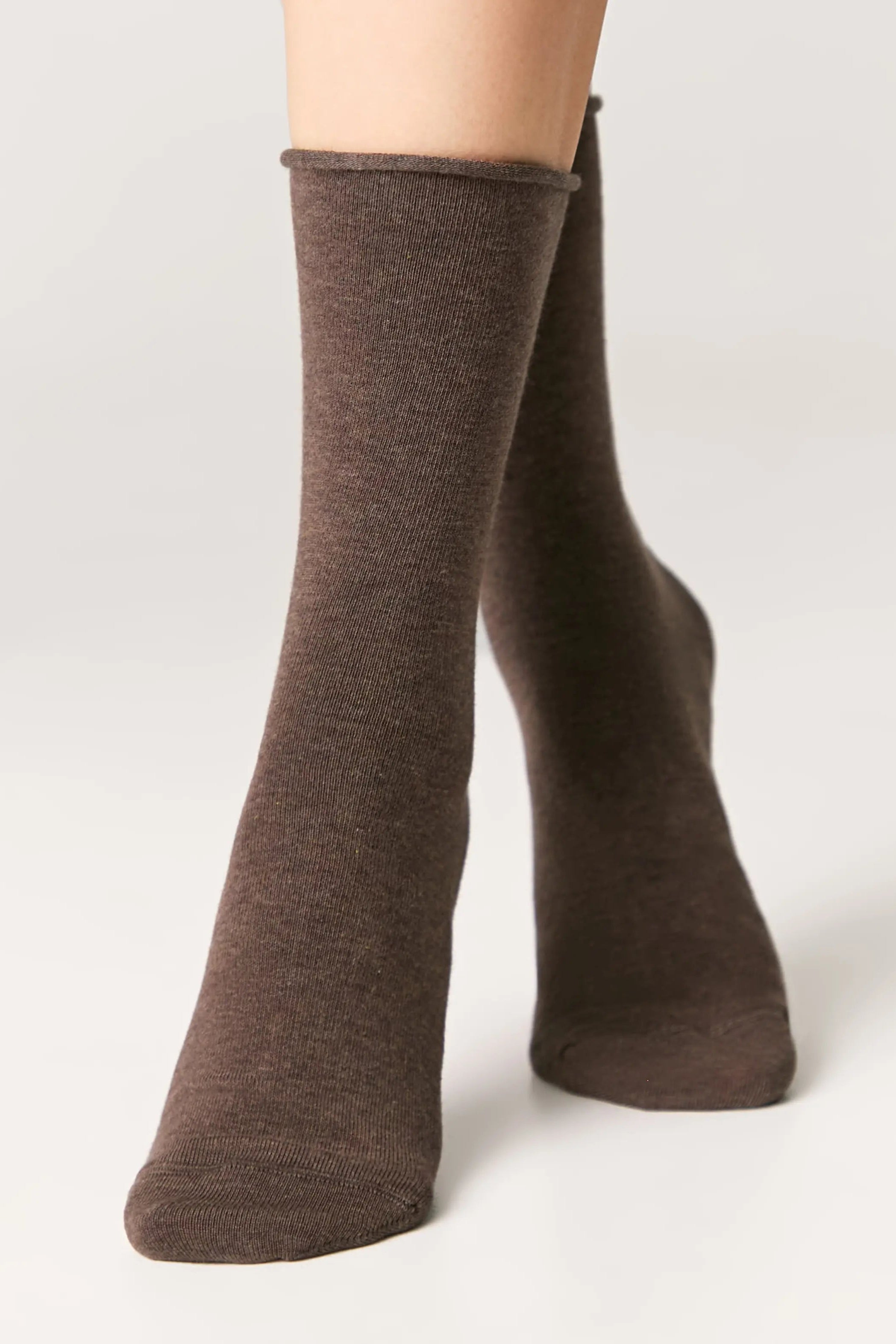 Brown socks worn by a person on a white background #color_brown