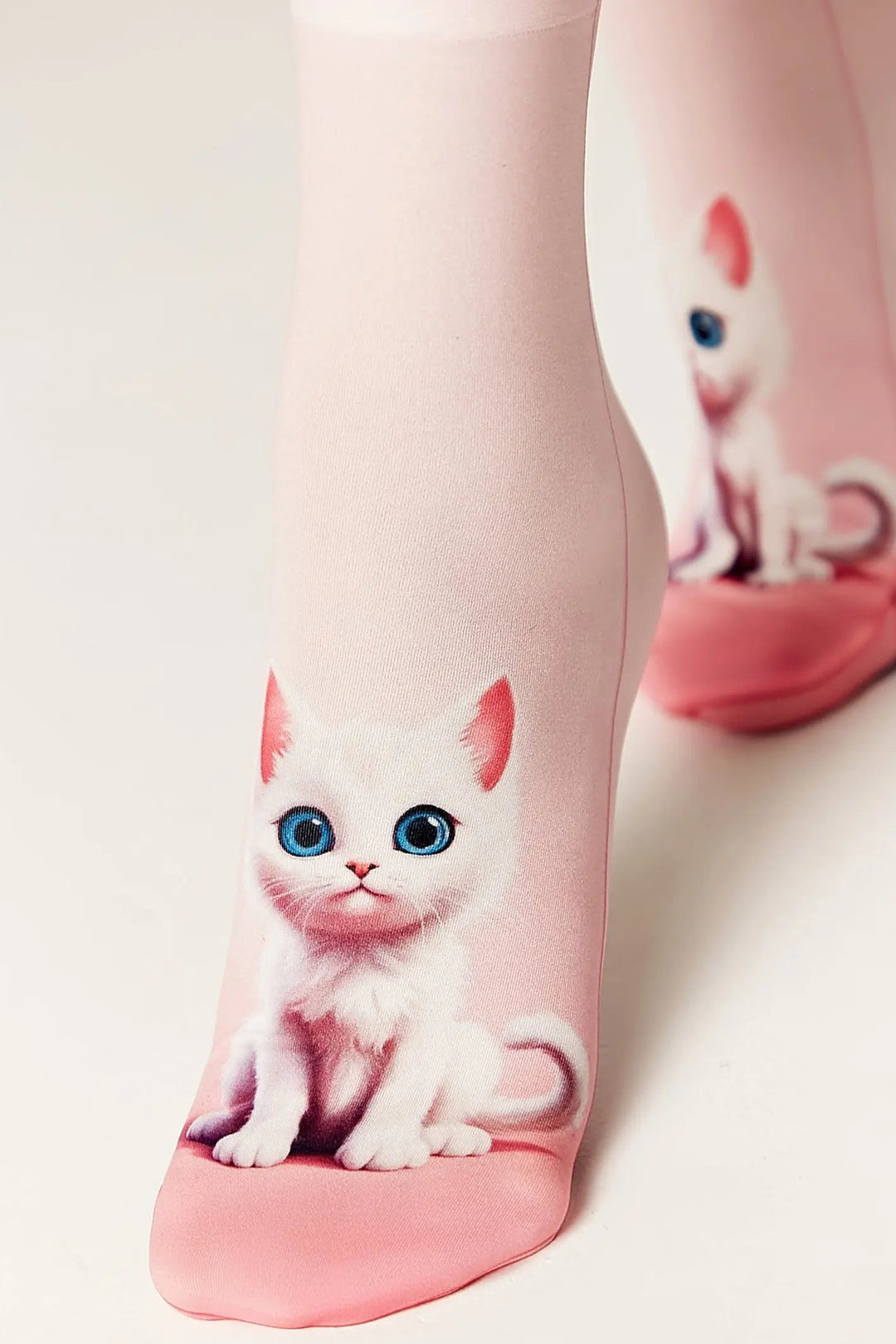 Socks with a design of a white cat with blue eyes on a light pink background.