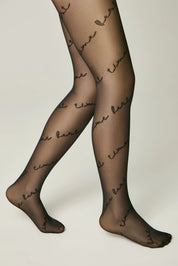 Black sheer tights with text pattern worn by a model on a neutral background #color_nero-black