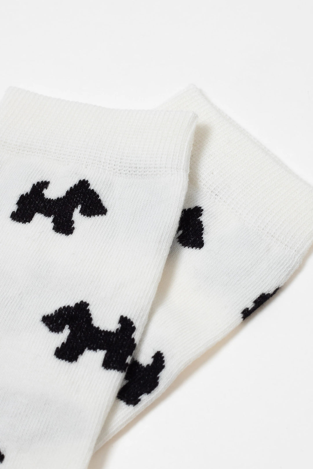 White socks with black dog pattern on a white background #color_milk