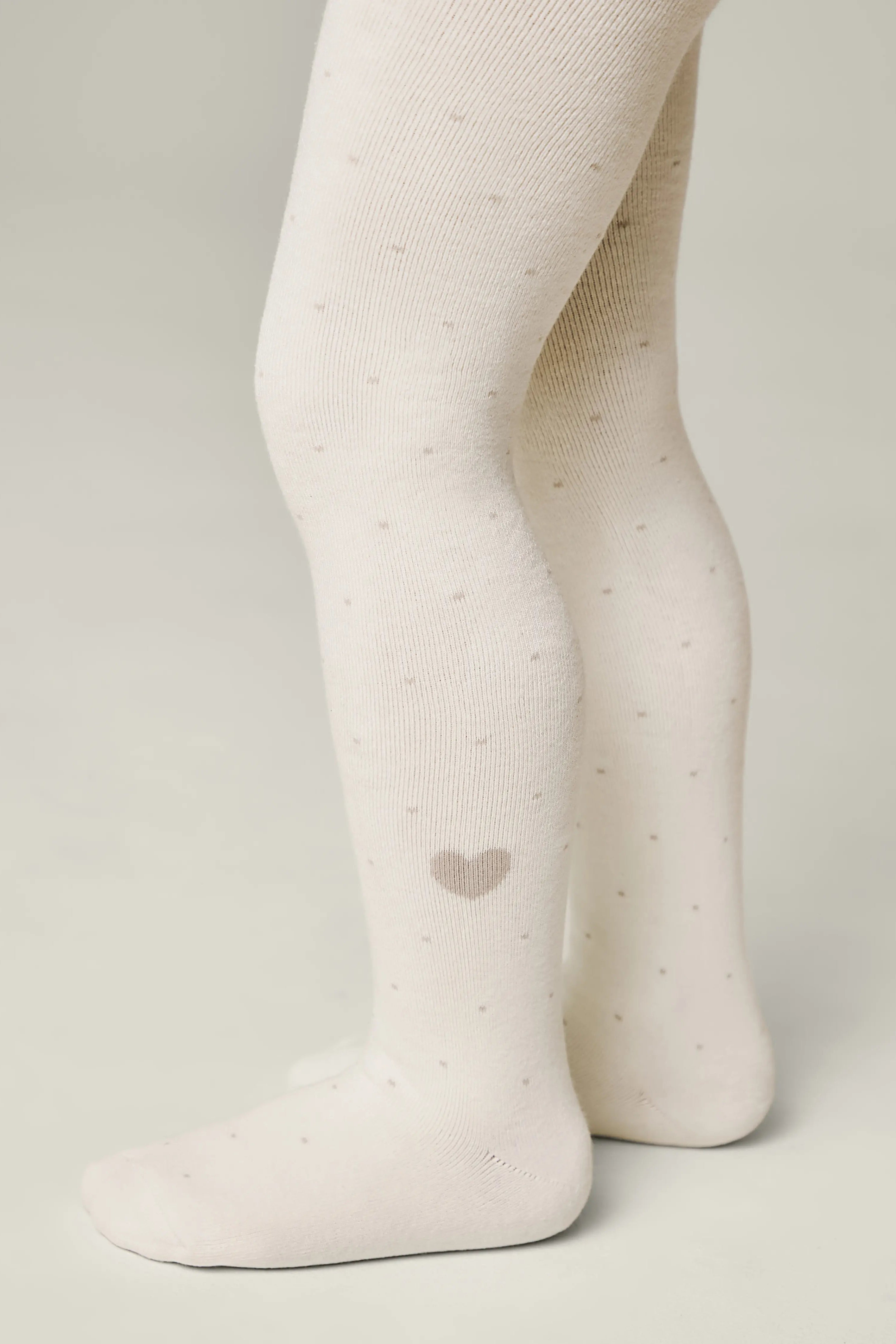White tights with a heart design on a plain background #color_milky