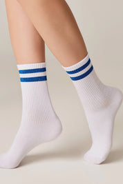 White socks with blue stripes worn by a person on a beige background #color_blue