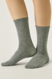 Gray socks worn by a person on a light gray background #color_gray