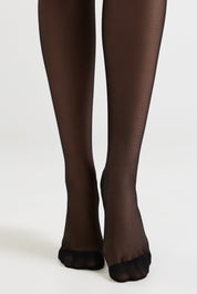 Black toeless hosiery shown on a model's legs against a plain light gray studio background.