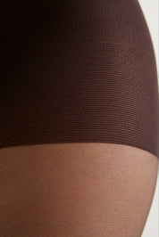 Close-up of sheer hosiery on a leg, showing a dark brown upper section and a sheer nude lower section.