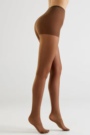 A model's lower body wearing sheer brown hosiery and a matching brown waistband, shown from a side profile against a light gray studio background.