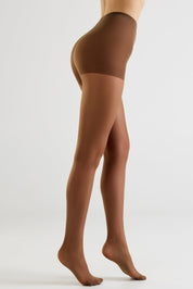 A model's lower body wearing sheer brown hosiery and a matching brown waistband, shown from a side profile against a light gray studio background.