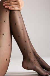 Brown polka dot tights worn by a person on a neutral background #color_grafit