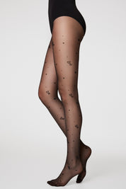 Sheer black tights with heart patterns worn by a person on a white background