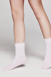 White socks worn by a person on a light gray background