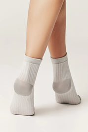 Gray ankle socks worn by a person on a light background #color_gray
