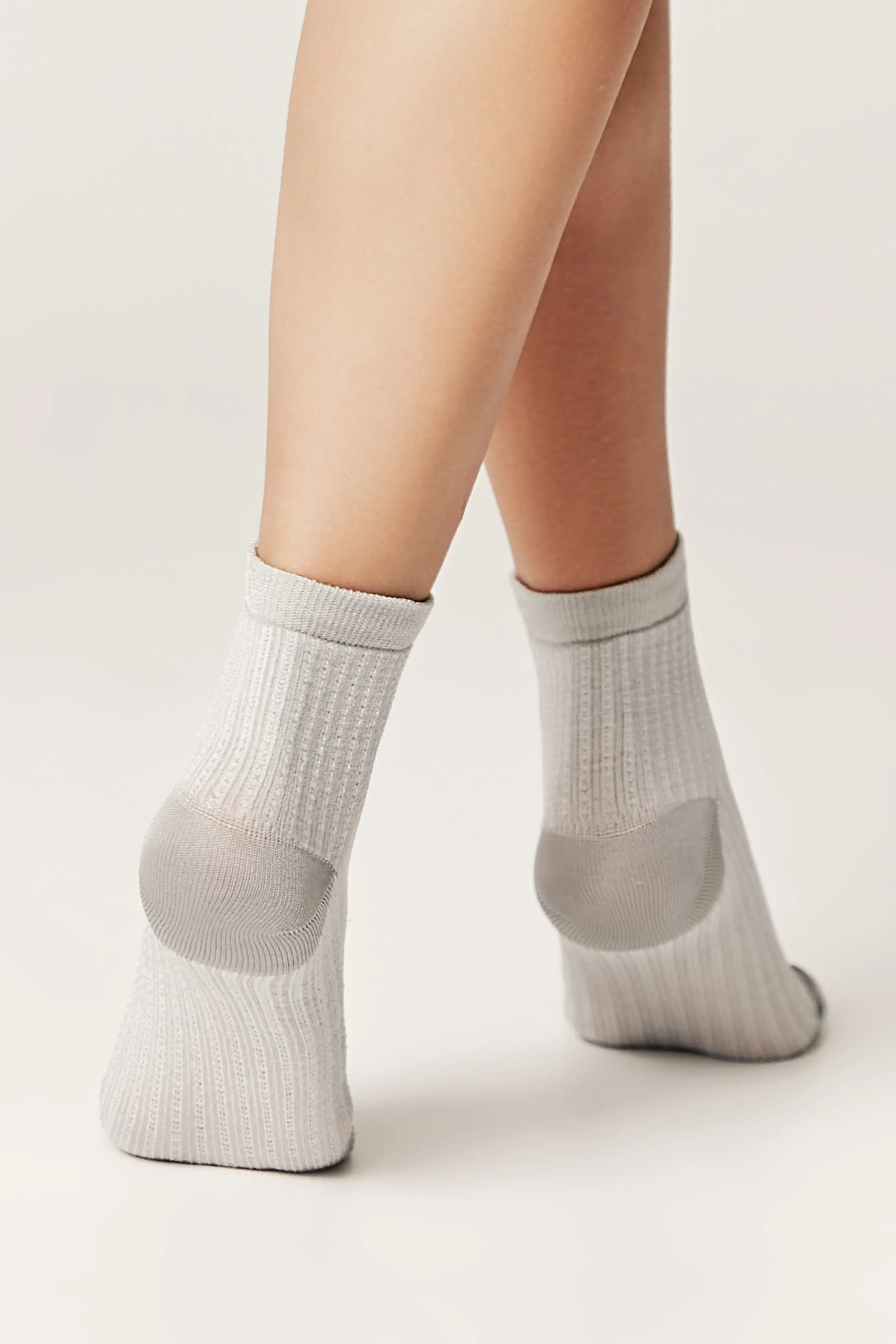 Gray ankle socks worn by a person on a light background #color_gray