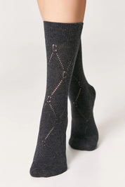 Dark gray socks with subtle pattern worn by a person on a light gray background #color_dark-gray