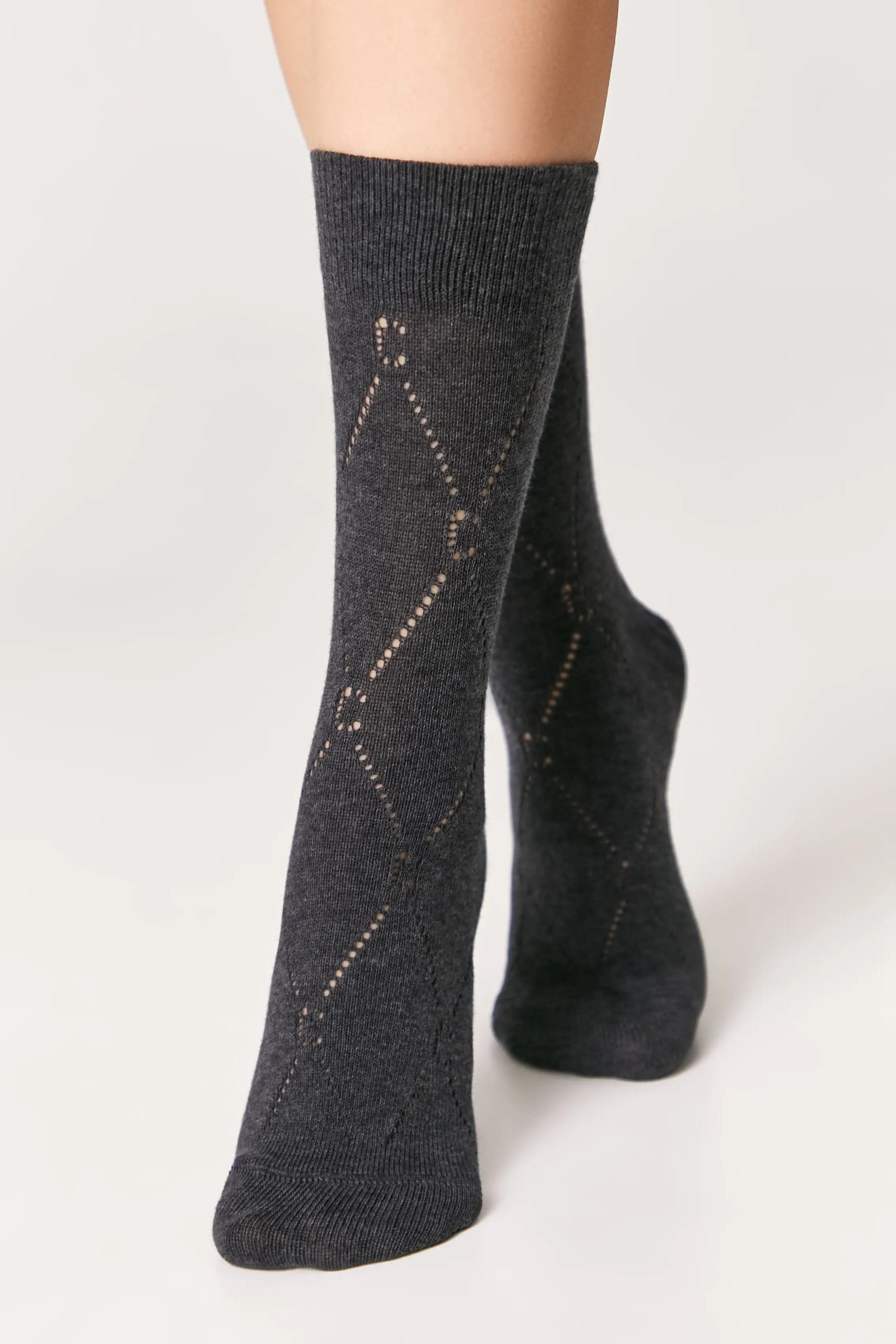 Dark gray socks with subtle pattern worn by a person on a light gray background #color_dark-gray