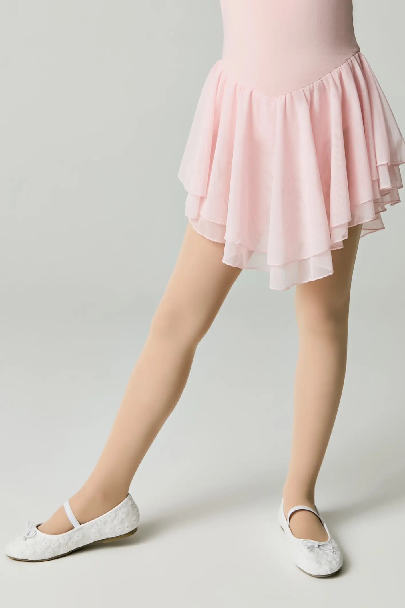 Person wearing a pink ballet outfit with a skirt on a plain background #color_natural-nude