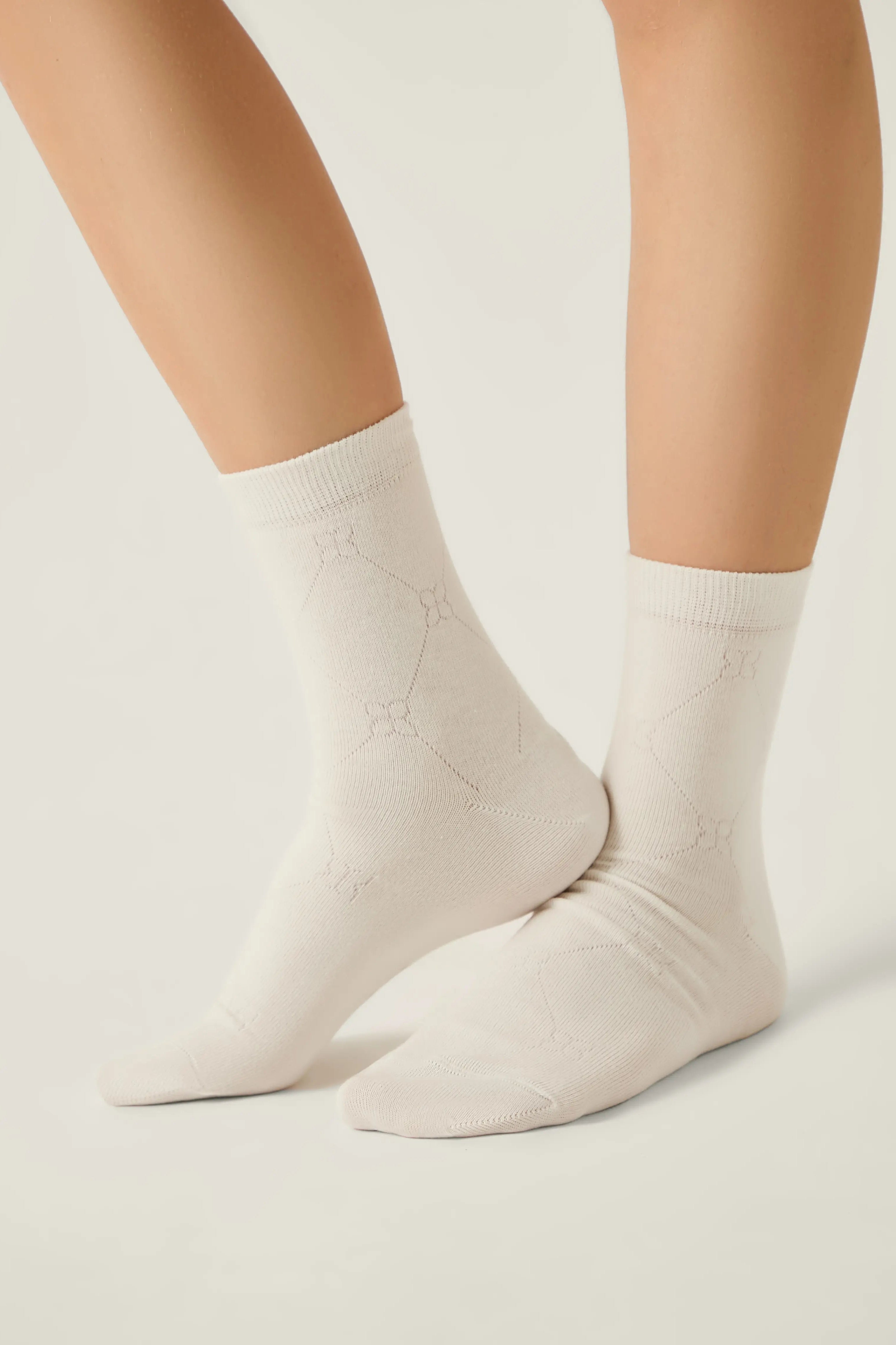 White socks worn by a person on a light gray background #color_milky