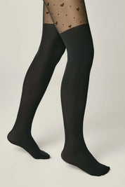 Black tights worn with patterned sheer stockings on a neutral background #color_nero-black