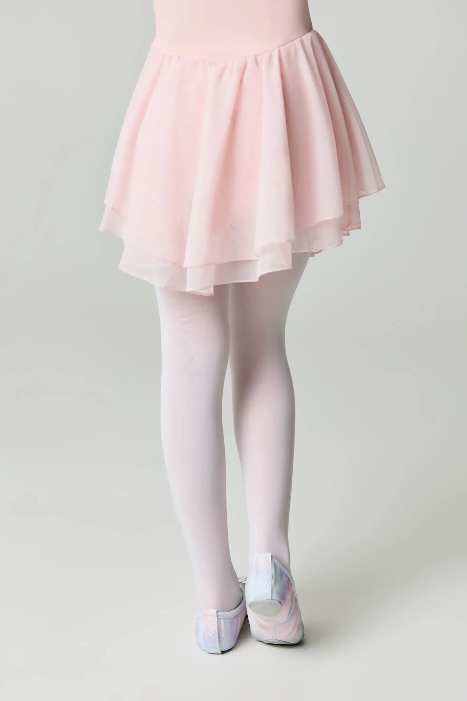 Person wearing a light pink skirt and tights on a plain background #color_bianco