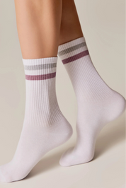 White socks with purple stripes worn by a person on a beige background #color_light-gray