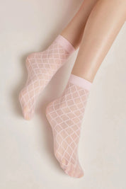 Pink fishnet socks worn by a person on a light background #color_light-pink