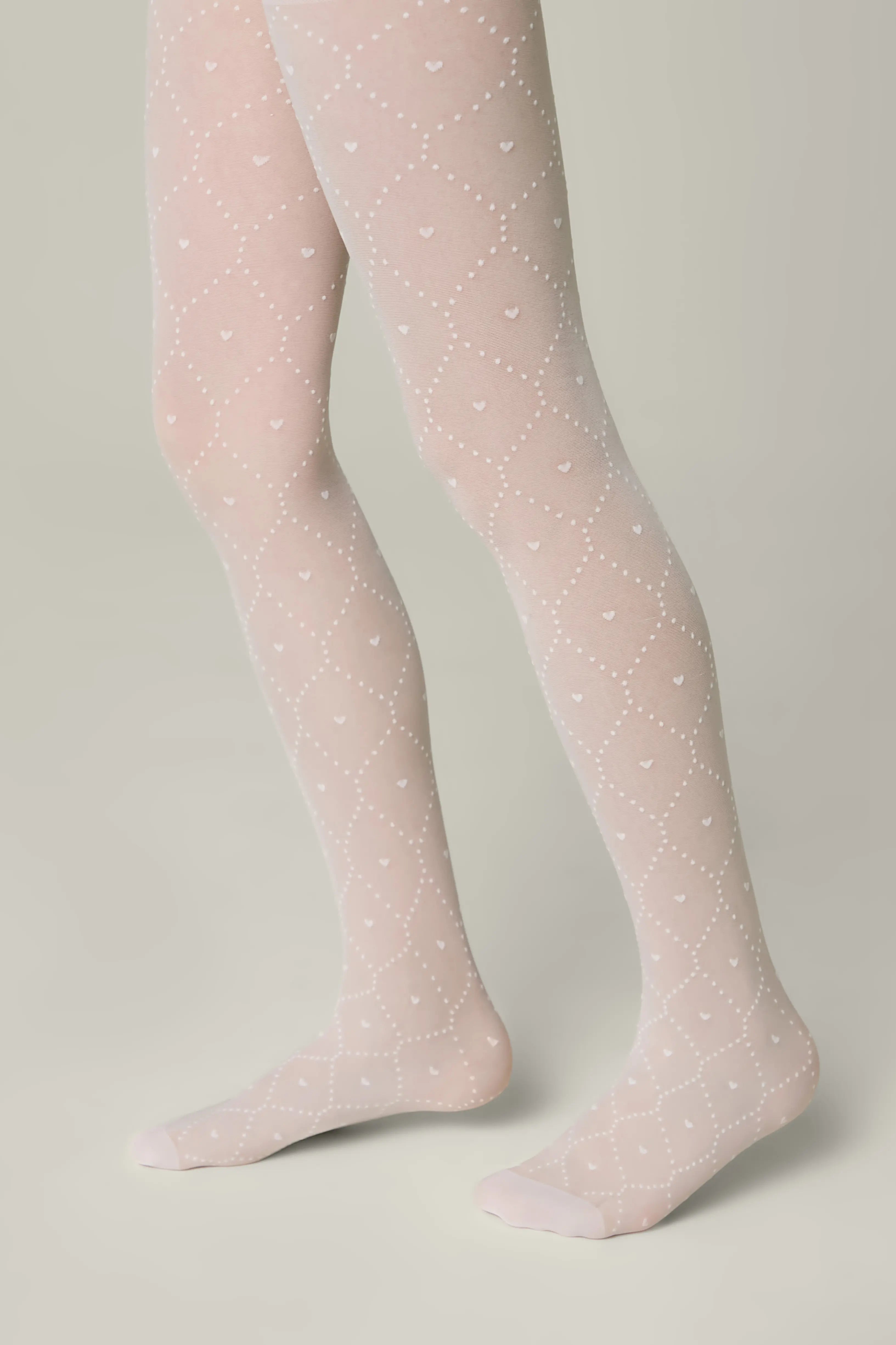 Pink tights with white polka dots worn by a person on a neutral background #color_bianco