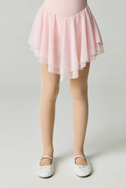 Person wearing a pink skirt and white shoes on a light gray background #color_natural-nude