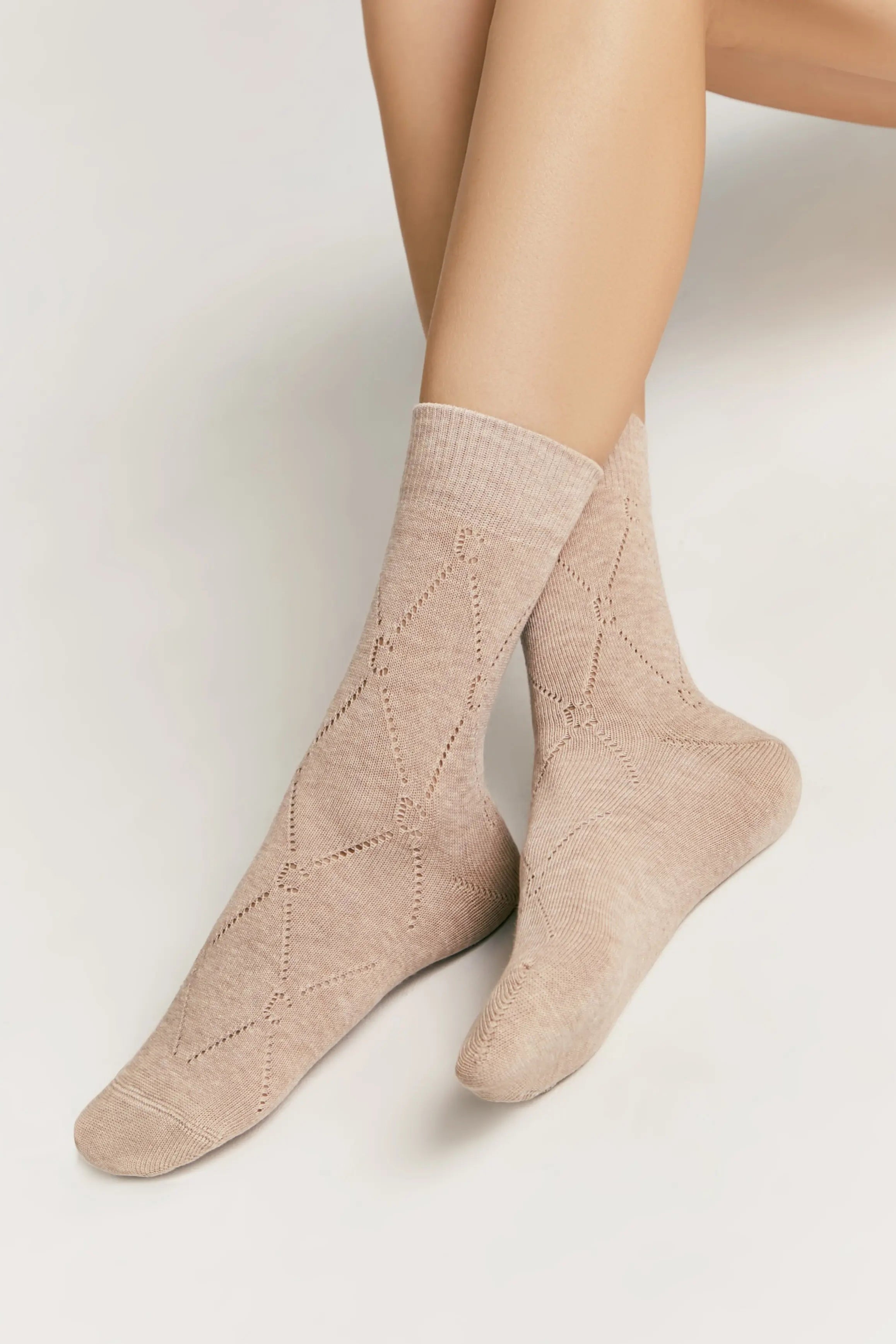 Beige socks worn by a person on a light gray background #color_beige