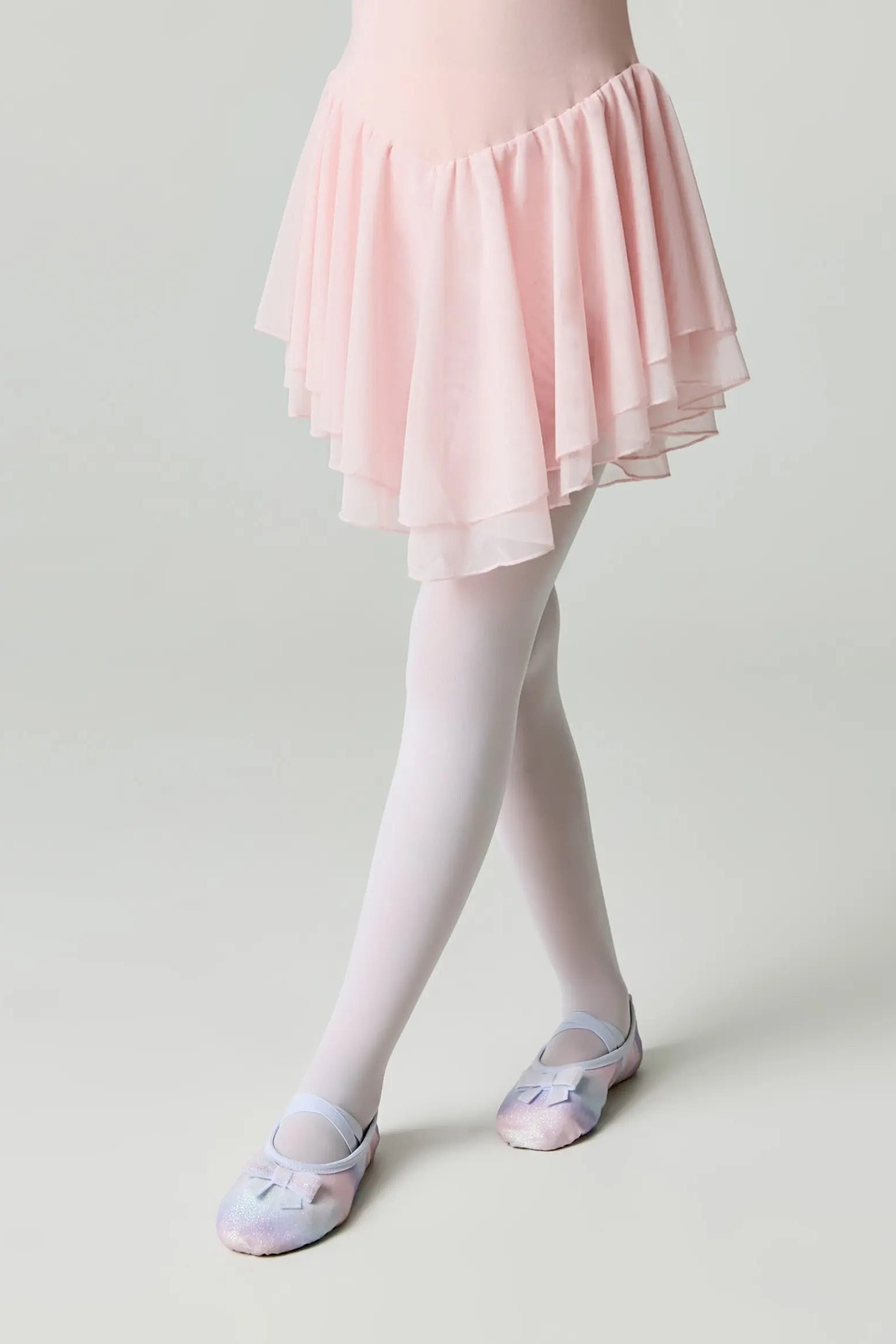 Person wearing a light pink ballet skirt, white tights, and ballet shoes on a plain background #color_bianco