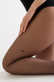 Close-up of a person wearing brown tights on a white background