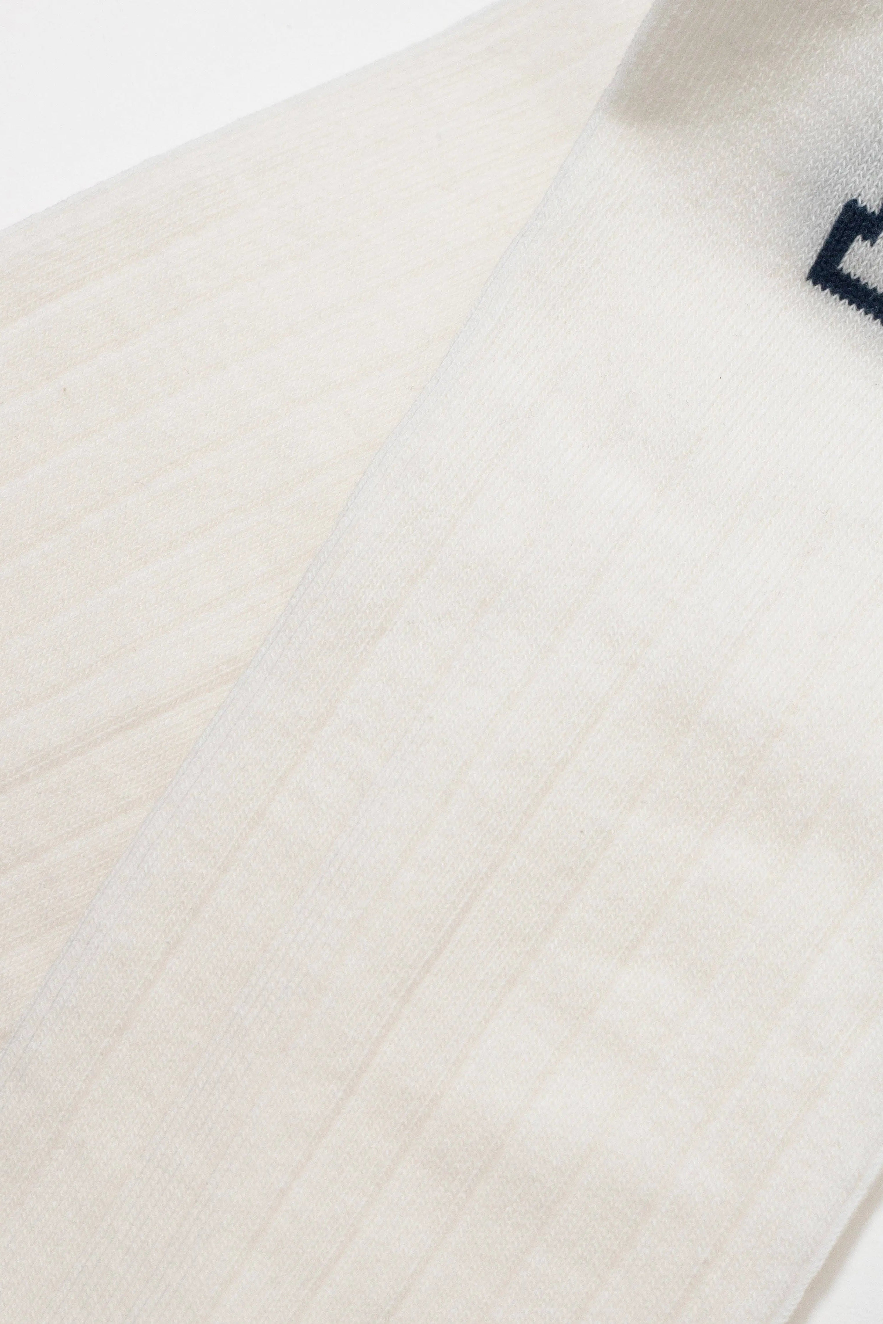 Close-up of a white fabric with a subtle pattern on a wooden surface