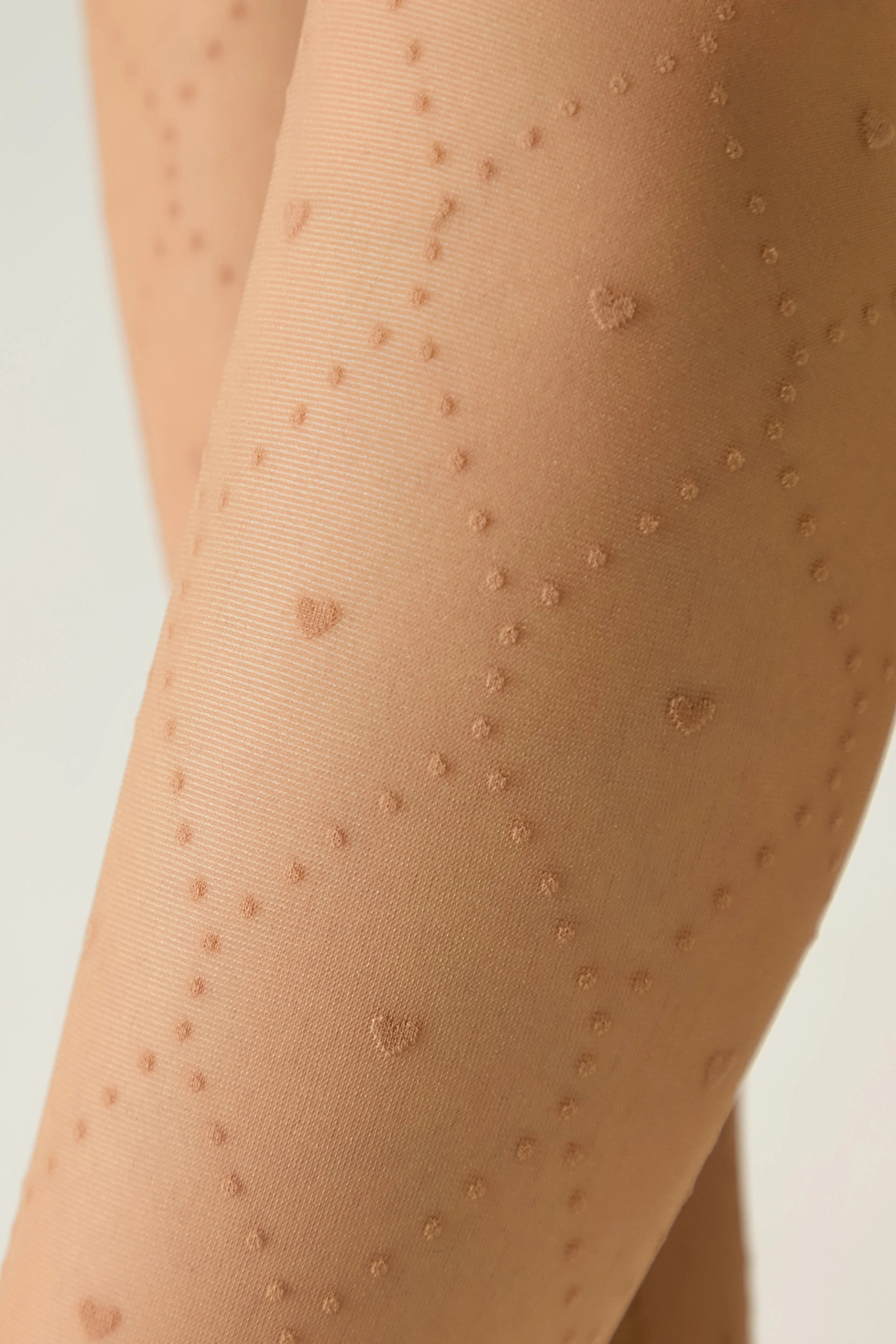 Beige tights with heart patterns on a light gray background #color_natural-nude